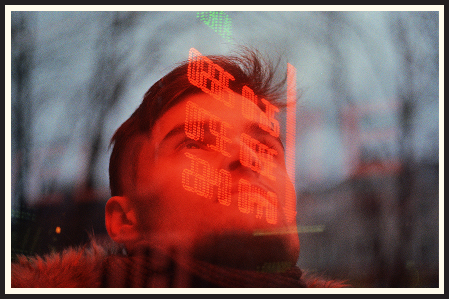 Film photo of a figure illuminated by red neon light