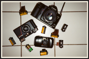 A collection of vintage film cameras and rolls of 35mm film