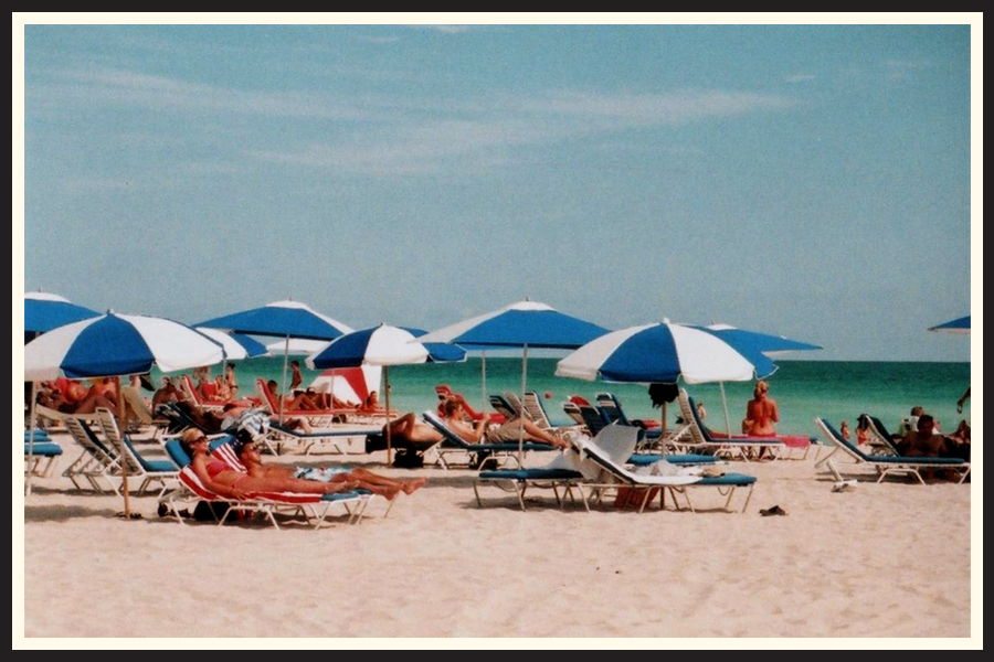 Film photo of beachgoers lounging under umbrellas in Miami