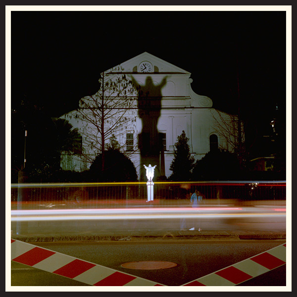 Film photo of a statue of a religious statue illuminated in the night