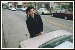 Film photo of someone and their car on the street in Pittsburgh