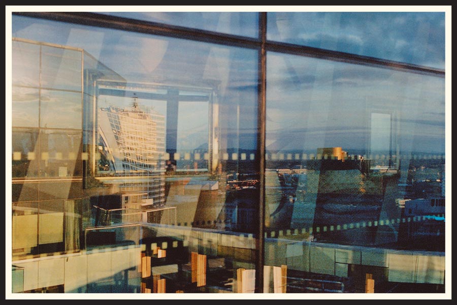 Film photo of a skyline reflected in a window.