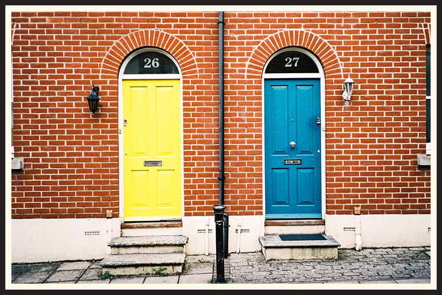 Film photos of a brick building in the UK with bright, colorful doors.