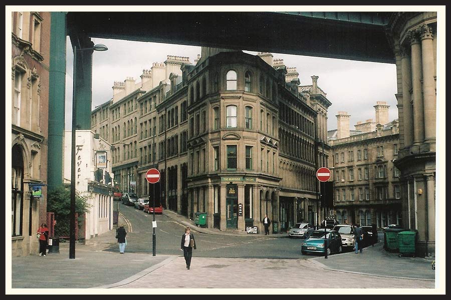 Film photo of a UK street located below a bridge.