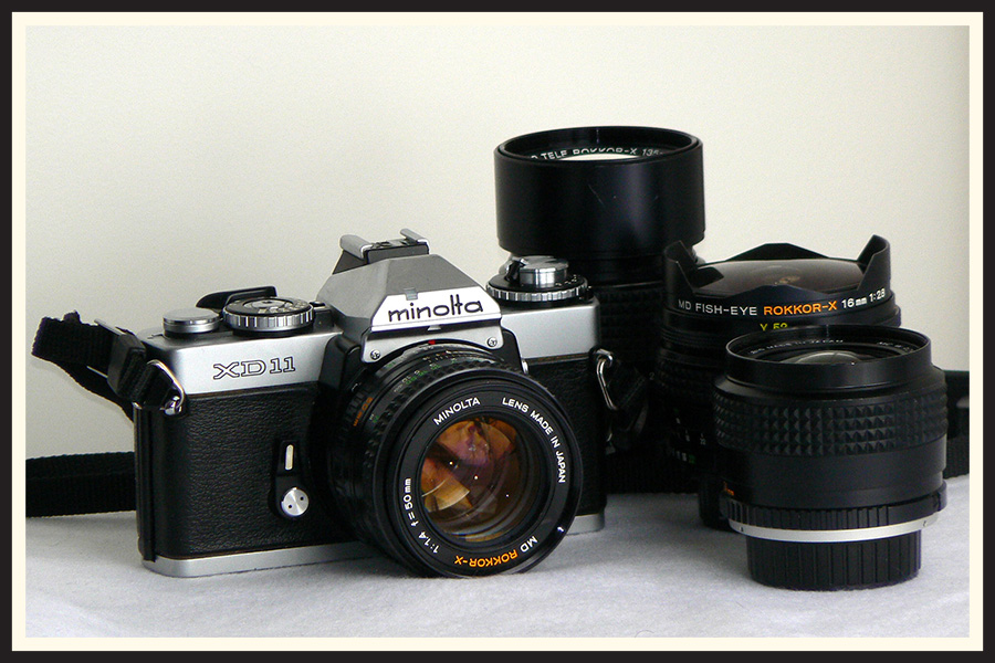 Minolta XD-11 SLR film camera with lenses.