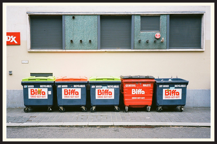 A line of blue and red dumpsters taken on Kodak Ektar 100 film.