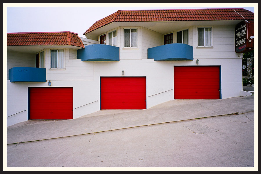 Film photo of three bright red garage doors in a line, taken on Kodak Ektar 100.