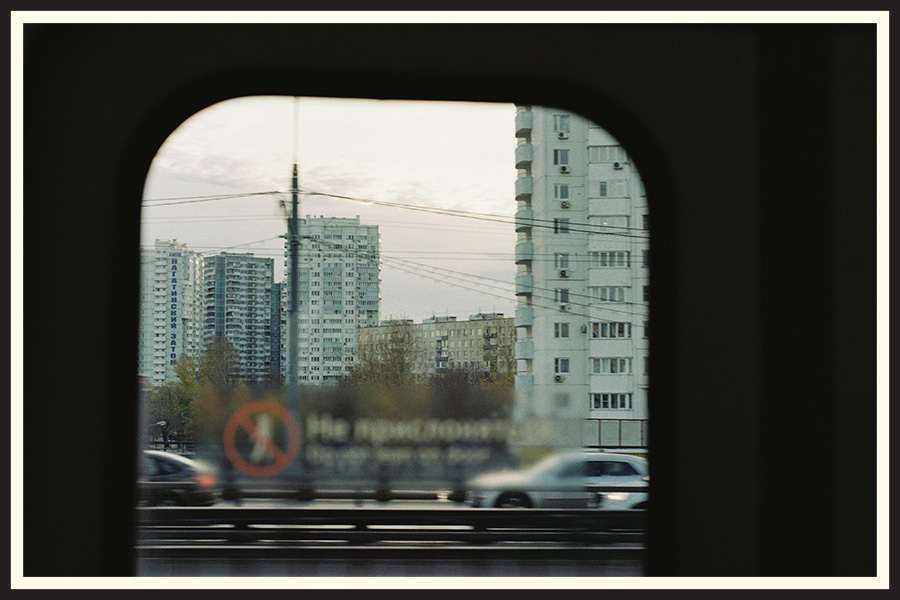 Film photo of a city skyline taken through the window of a train, taken on Kodak Colorplus 200.