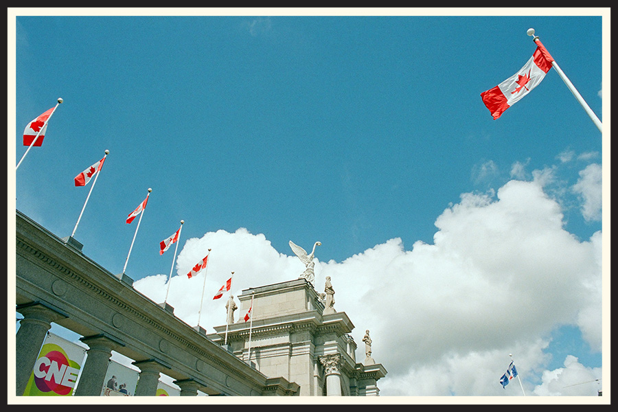 A line of Canadian flags flying on a cloudy day, taken on Portra 800 film.