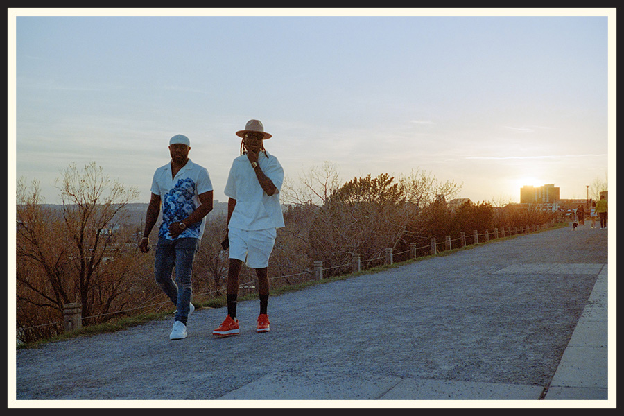 Two men in hats walk by as the sun sets in the background, taken on Portra 800 color film.