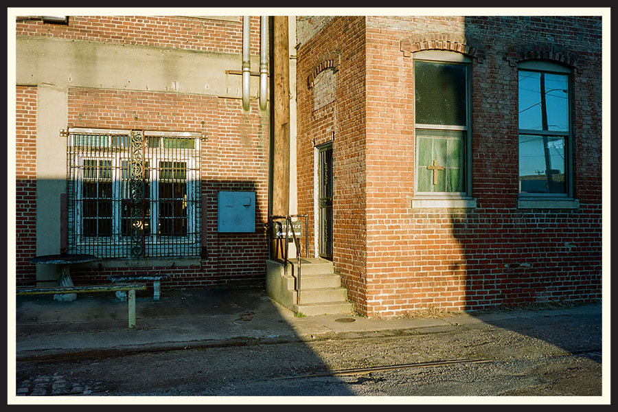 An old, brick building, half covered in shadow, taken on Portra 800 film.